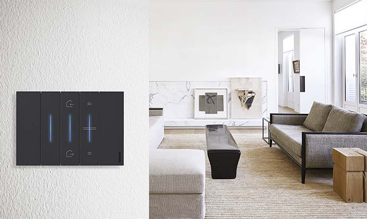 Soggiorno moderno con interruttore smart BTicino Living Now connesso nero su parete texturizzata in primo piano.