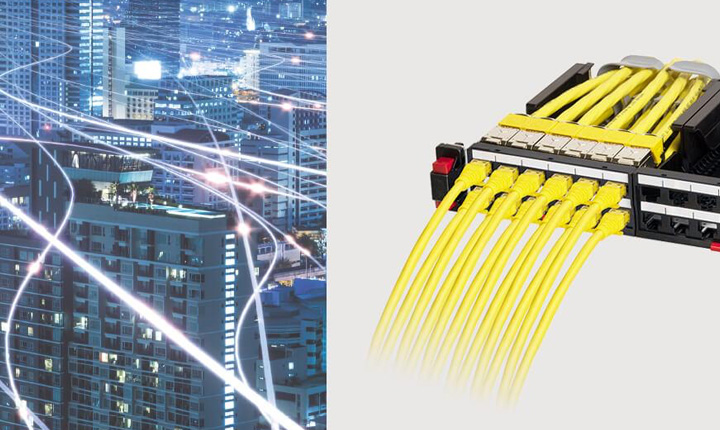 Cavi di rete connessi ad un UPS e vista di palazzi in città con scie luminose.