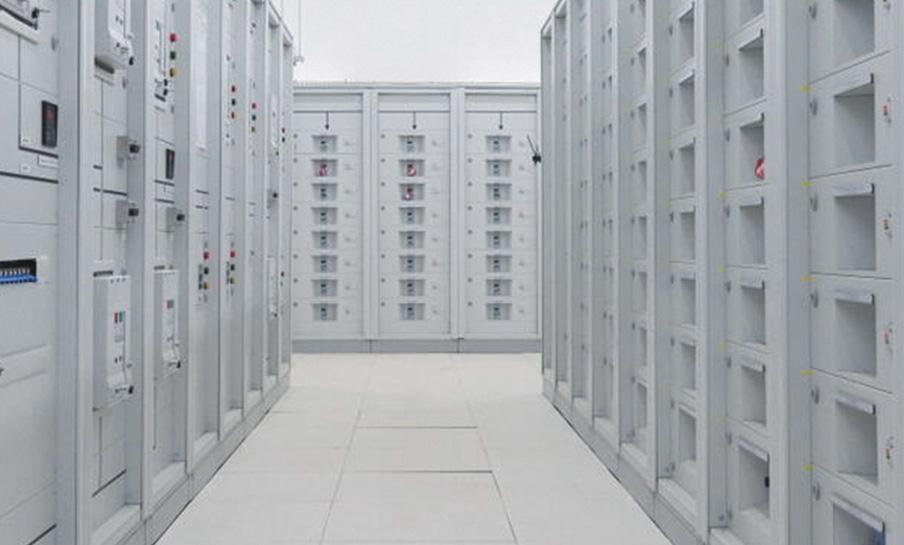 Un corridoio fiancheggiato da file di rack di server bianchi in un centro dati o in una sala server ben illuminati.